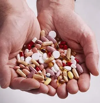 Assorted pills and supplements held in open hands, representing on-demand options